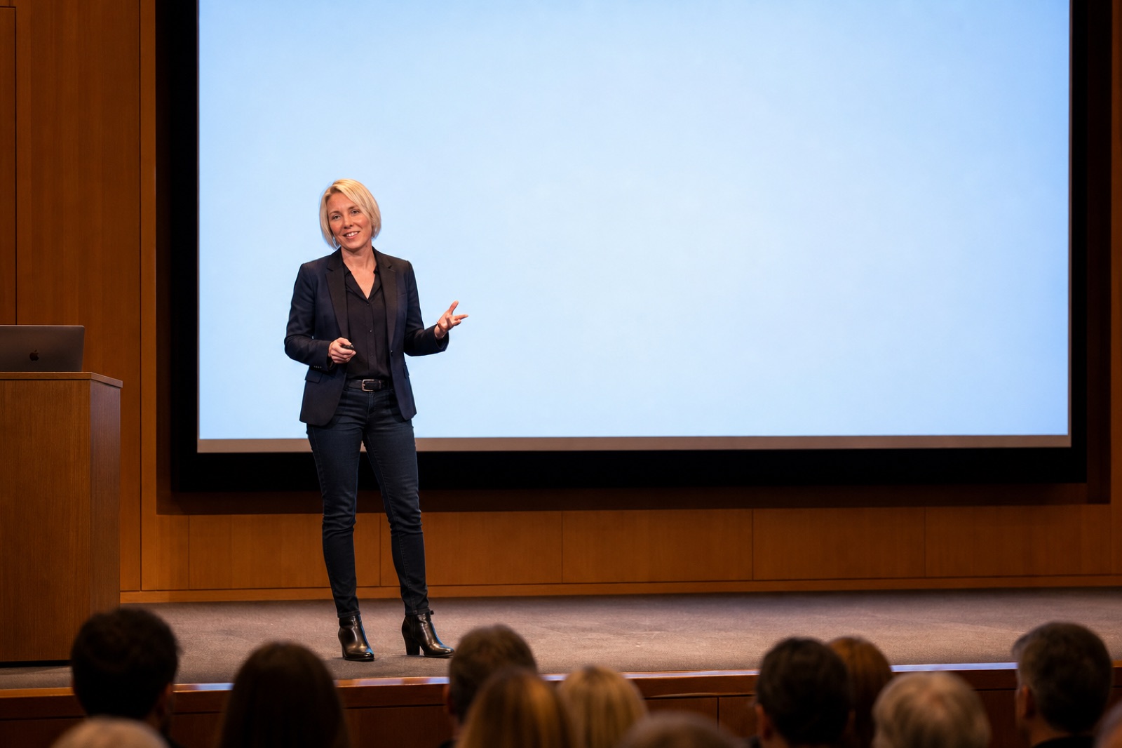 Helen föreläser på en scen inför en fullsatt publik